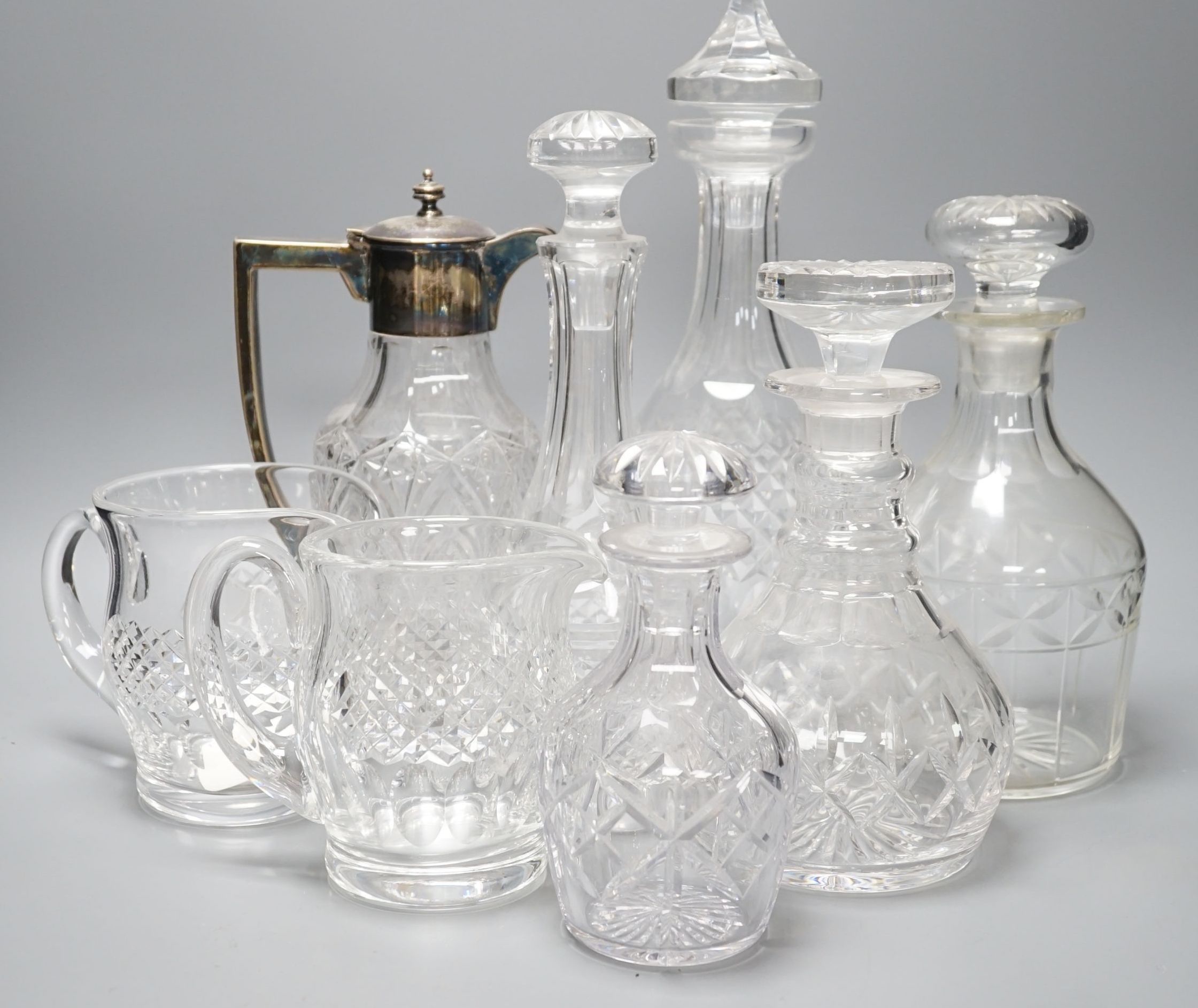 A group of assorted cut glass including decanters, a silver mounted claret jug, two milk jugs, tallest 33cm